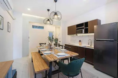 a kitchen with a wooden table and a refrigerator at Private 4BR Model Home center Patong in Patong Beach