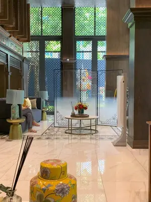 a lobby with a large window and a table at The Base Central Phuket in Phuket Town