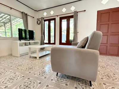 a living room with a couch and a chair and a television at Modern Sunset Sea House Lam Sai in Ko Yao Noi