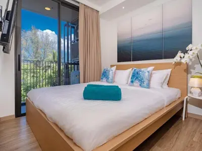a bedroom with a large bed with a large window at Bangtao , Laguna , 5 minutes from the bench, 2 bedroom in Ban Thalat Choeng Thale
