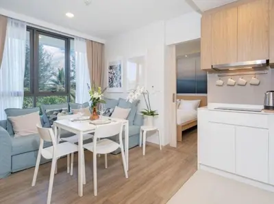 a kitchen and living room with a white table and chairs at Bangtao , Laguna , 5 minutes from the bench, 2 bedroom in Ban Thalat Choeng Thale