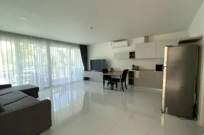a kitchen and living room with a table and a refrigerator at Karon Butterfly Condominium Brandnew 68m2 apartment, seaview, pool access, 500m to beach in Karon Beach