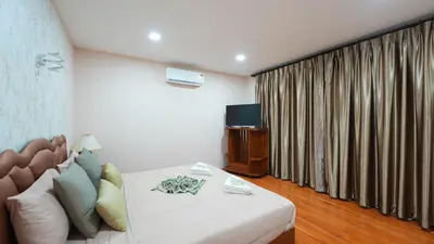 a living room with a couch and a television at So View Phuket Resort in Ban Sam Kong