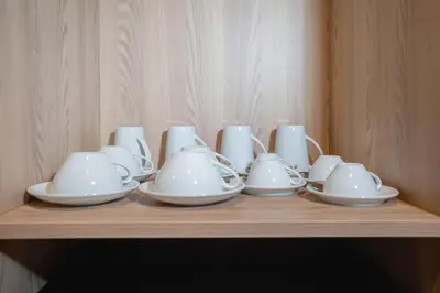 a group of cups and saucers on a wooden shelf at Pool Access Condo Bangtao Beach in Bang Tao Beach