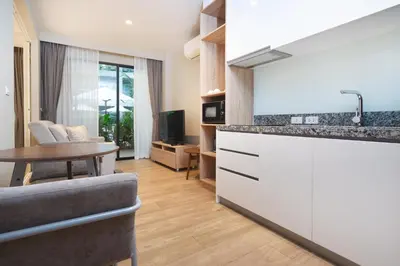 a kitchen and living room with a table and a couch at Pool Access Condo Bangtao Beach in Bang Tao Beach
