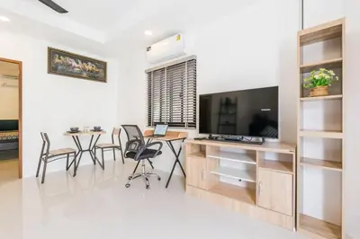 a living room with a television and a table and chairs at Chonlada Pool Villa - 6-BR - Kamala Beach in Phuket Town
