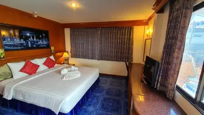 a hotel room with a bed and a television at Vech Guesthouse Patong in Patong Beach