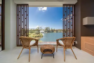 a room with two chairs and a large window at Laguna Angsana Apartments Lake View in Bang Tao Beach