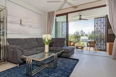 a living room with a couch and a glass table at Laguna Angsana Apartments Lake View in Bang Tao Beach