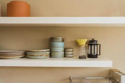 a shelf with plates and other dishes on it at Casa Solana Patong in Patong Beach