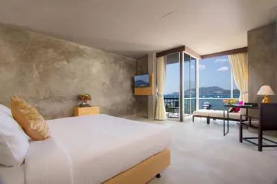 a bedroom with a large bed and a large window at Patong Signature Boutique Hotel in Patong Beach