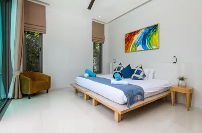 a bedroom with a large bed and a chair at Villa Mimosa 1, Luxury 4BR with Private Pool/Rawai in Phuket Town