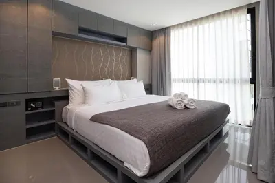 a bedroom with a large bed with a large window at Tropics Kamala Deluxe Pool View Apartment CTG P402 in Kamala Beach