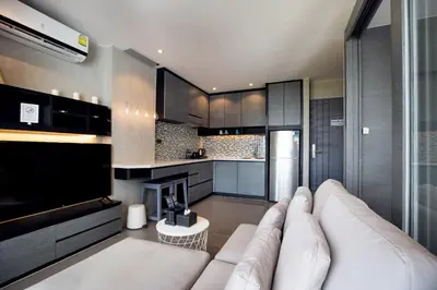 a living room with a couch and a kitchen at Tropics Kamala Pool View Residence CTG B704 in Kamala Beach