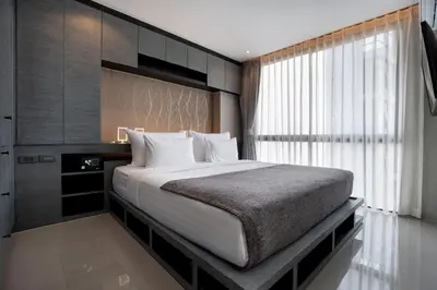a bedroom with a large bed and a window at Tropics Kamala Pool View Residence CTG B704 in Kamala Beach