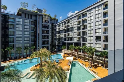 an apartment complex with a swimming pool and palm trees at Tropics Kamala Pool View Residence CTG B704 in Kamala Beach