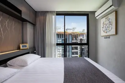 a bedroom with a large bed with a large window at tropics Kamala Deluxe Pool View Apartment CTG P602 in Kamala Beach
