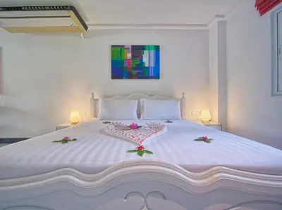 a bedroom with a large white bed with flowers on it at Serenity Lakeside Resort in Kathu