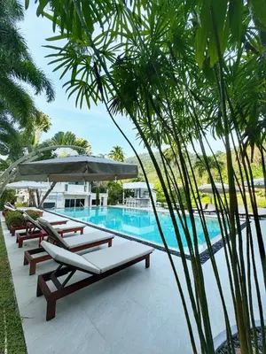 a swimming pool with lounge chairs and an umbrella at Serenity Lakeside Resort in Kathu