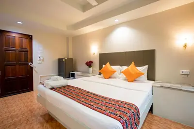 a bedroom with a large white bed with orange pillows at Tri's Miracle Kata Beach Side in Kata Beach
