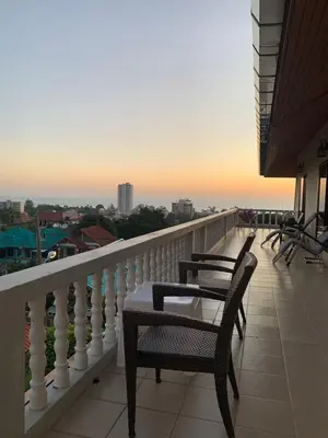 a balcony with two chairs and a table on it at Scan House Apartment in Karon Beach
