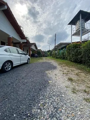 a white car parked on the side of a driveway at Peaceful 2BR Garden Retreat Bangtao Beach A2 in Ban Thalat Choeng Thale