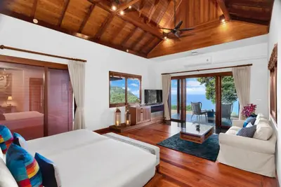 a bedroom with a bed and a living room at Villa Varya in Amphoe Thalang