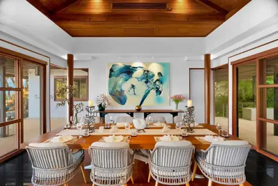 a dining room with a large wooden table and chairs at Villa Varya in Amphoe Thalang