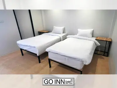 two beds with white sheets in a room at xx GO INN Phuket Old Town ภูเก็ตโอลทาวน์ ย่านเมืองเก่า in Phuket Town