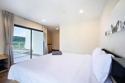 a bedroom with a white bed and a large window at Patong tower Superior Seaview 4BR-2102 in Patong Beach
