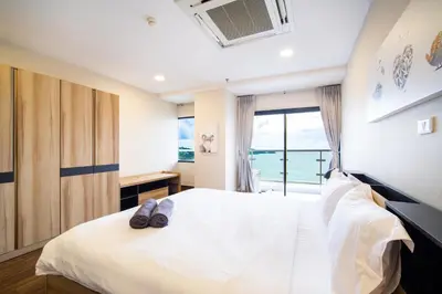a bedroom with a bed with a view of the ocean at Patong tower Superior Seaview 4BR-2102 in Patong Beach