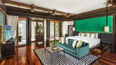 a bedroom with a bed and a green wall at Villa Purissara in Phuket Town
