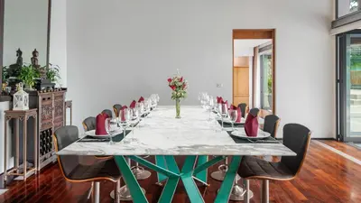 a dining room with a long table and chairs at Villa Lomchoy in Phuket Town