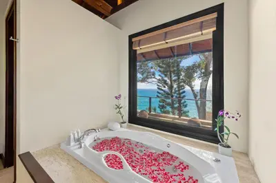 a bathroom with a bath tub filled with pink flowers at Villa Horizon in Phuket Town