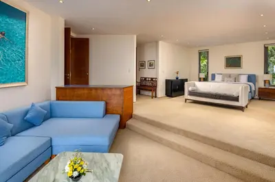 a living room with a blue couch and a bed at Villa Fah Sai in Phuket Town