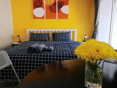 a bedroom with a bed with a table and flowers at KARON STUDIO APARTMENT in Karon Beach