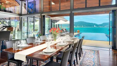 a dining room with a long table and chairs at Villa Rom Trai in Kathu