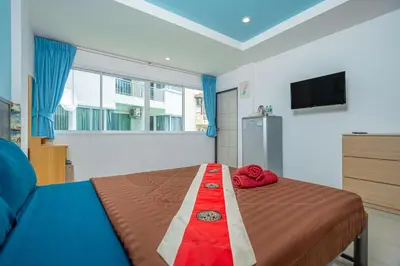 a bedroom with a bed and a television in it at Nice to meat you Rooms in Patong Beach