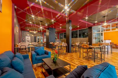 a living room with blue couches and tables and chairs at Nice to meat you Rooms in Patong Beach