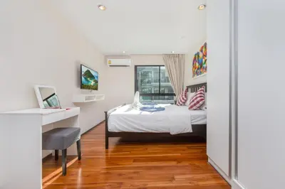 a bedroom with a bed and a desk and a window at The Title Condo by Tropiclook in Rawai Beach