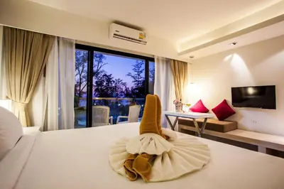 a hotel room with a bed with a towel on it at Coral Inn in Karon Beach