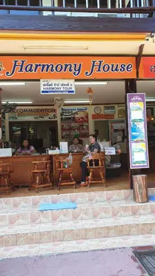 a man sitting in front of a hamory house at Harmony House-SHA Plus in Phi Phi Don