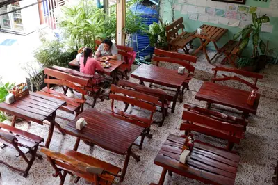 a group of people sitting at tables in a restaurant at Harmony House-SHA Plus in Phi Phi Don