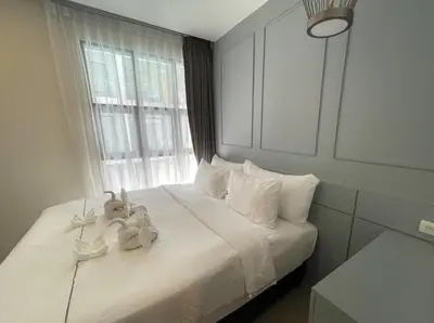 a bedroom with a white bed with stuffed animals on it at Modern Condo Palmyrah by Lofty in Surin Beach