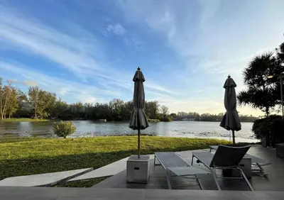 two umbrellas and two chairs sitting next to a river at Best location in Laguna-modern apartment at Cassia in Bang Tao Beach