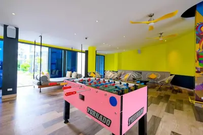 a living room with a foosball table in the middle at Best location in Laguna-modern apartment at Cassia in Bang Tao Beach