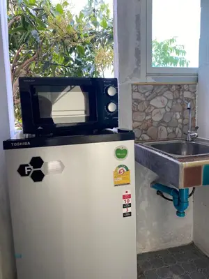 a microwave on top of a refrigerator next to a sink at Кондо в райском уголке Равай in Rawai Beach