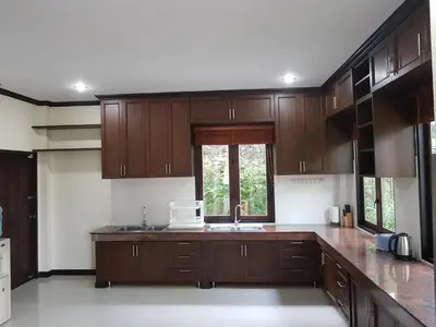 a kitchen with wooden cabinets and a sink and a window at ViewPoint Villa in Kathu