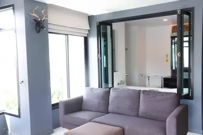 a living room with a couch and a large mirror at Coco boutique hotel in Patong Beach