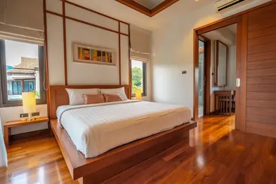 a bedroom with a large bed with a wooden headboard at Villa Autjima krabi /3BRD in Ban Khlong Haeng